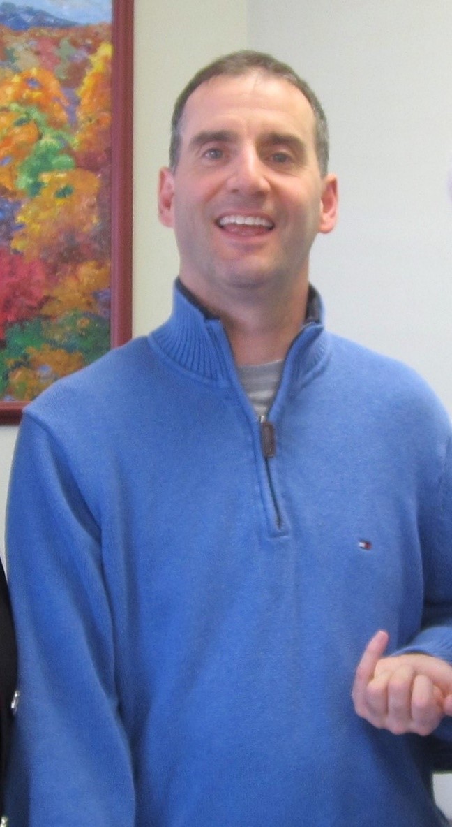 Michael Coss in a blue shirt and a smile